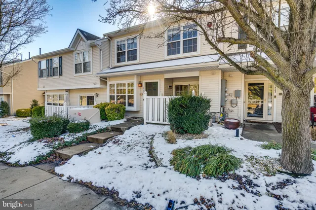 a view of a house with a bench in a backyard