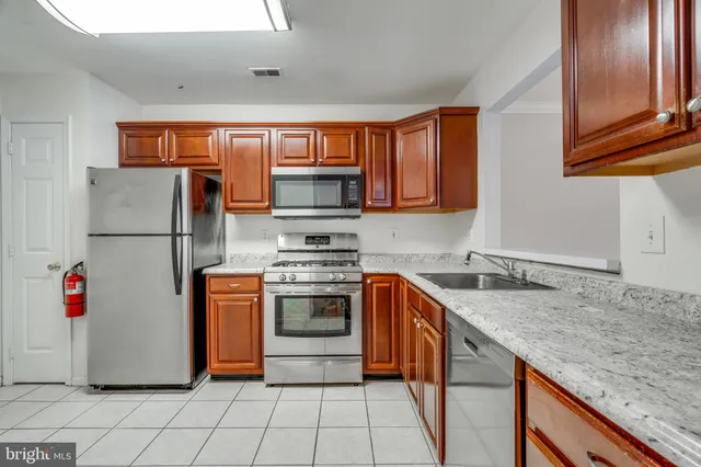 a kitchen with stainless steel appliances granite countertop a refrigerator sink and stove