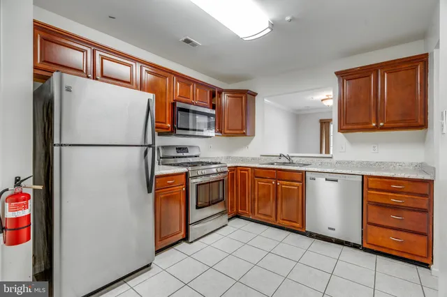 a kitchen with stainless steel appliances granite countertop a refrigerator and a stove top oven