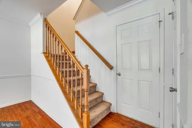 a view of staircase with wooden floor and white walls