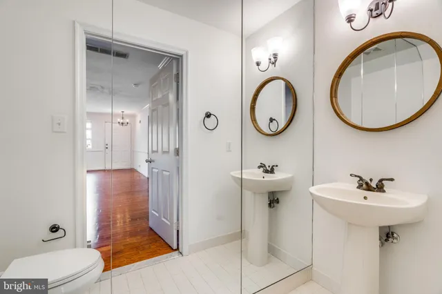 a bathroom with a toilet a sink and a mirror