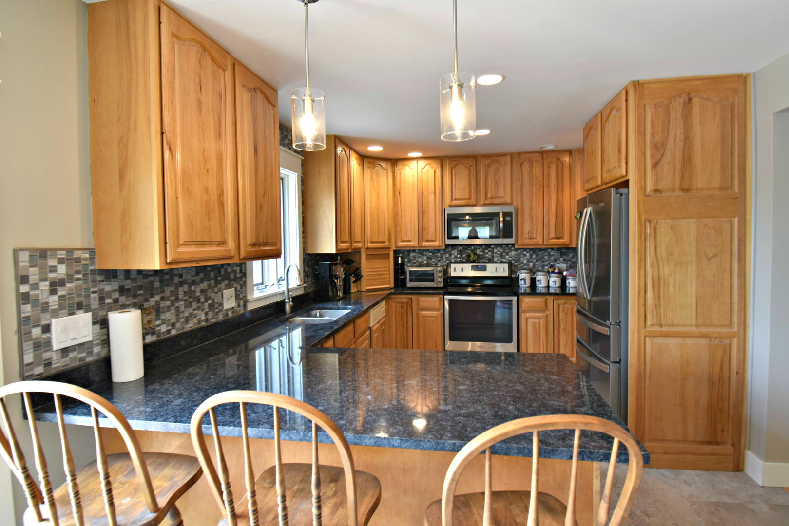 8101 Greenwood Road Hebron, IL 60034 - Photo 13 of 39 a kitchen with stainless steel appliances granite countertop a refrigerator a stove top oven a sink dishwasher and wooden cabinets