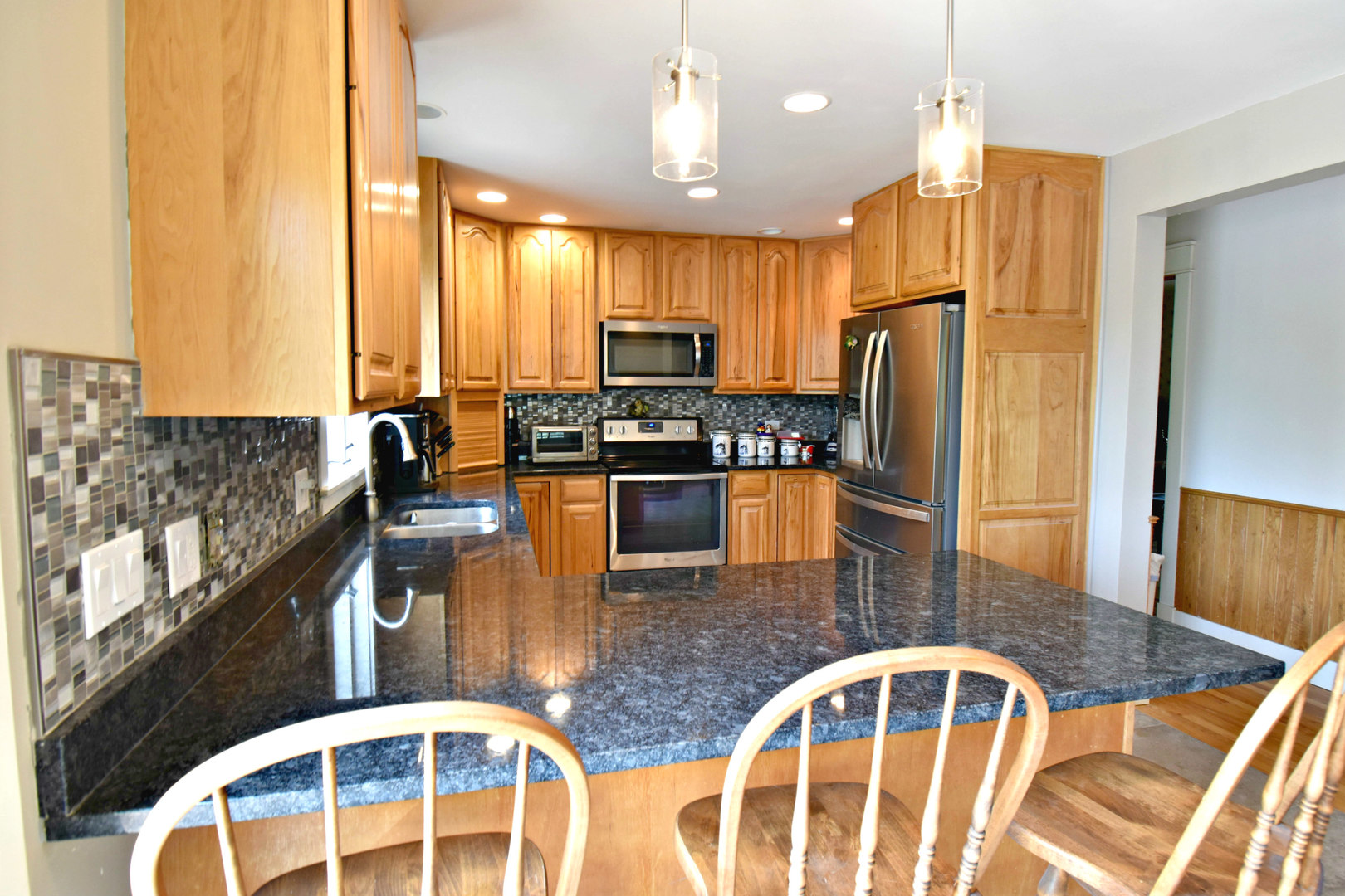 8101 Greenwood Road Hebron, IL 60034 - Photo 16 of 39 a kitchen with stainless steel appliances granite countertop a stove a refrigerator and a dining table