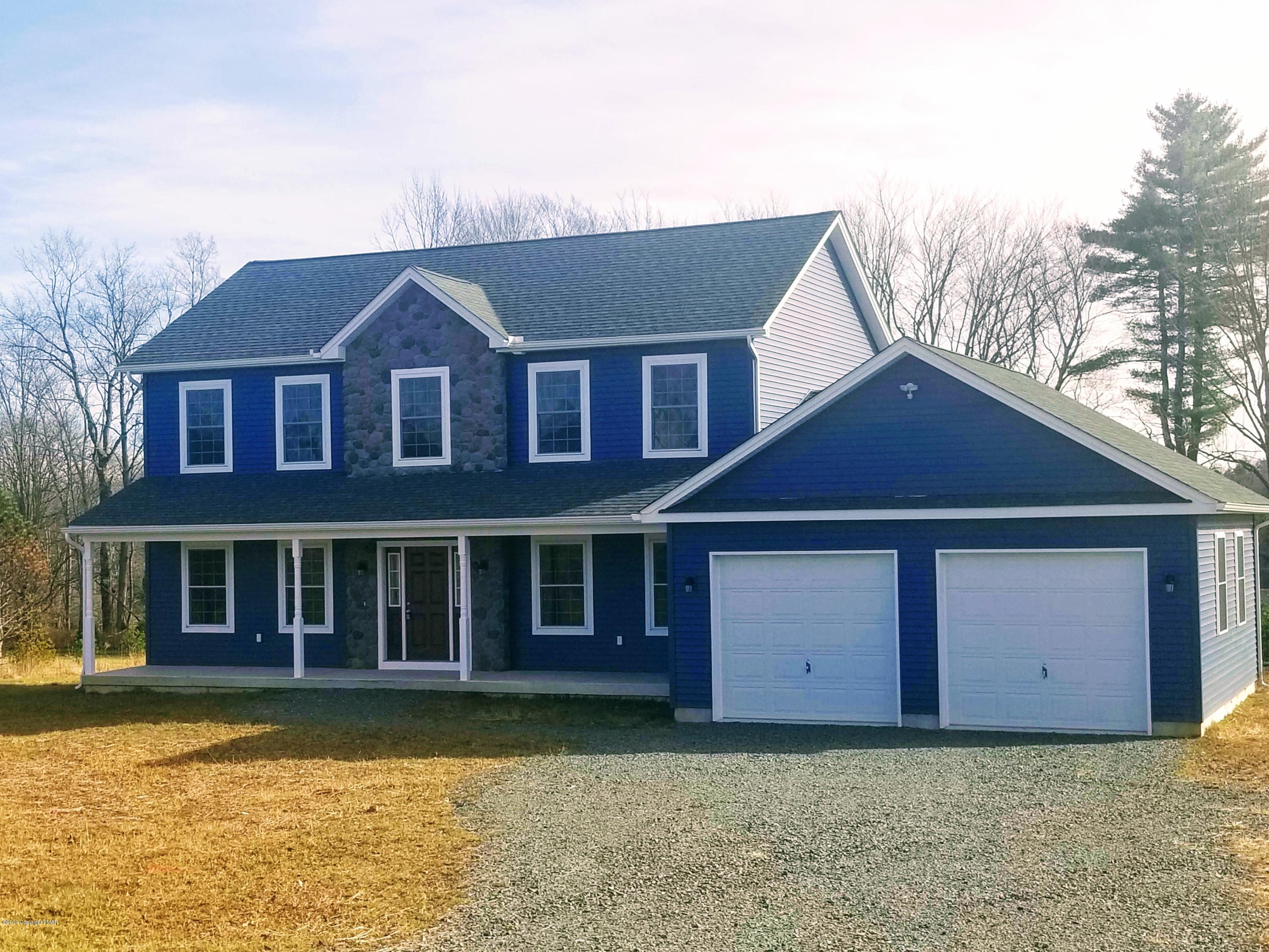 a front view of a house with a garden and yard