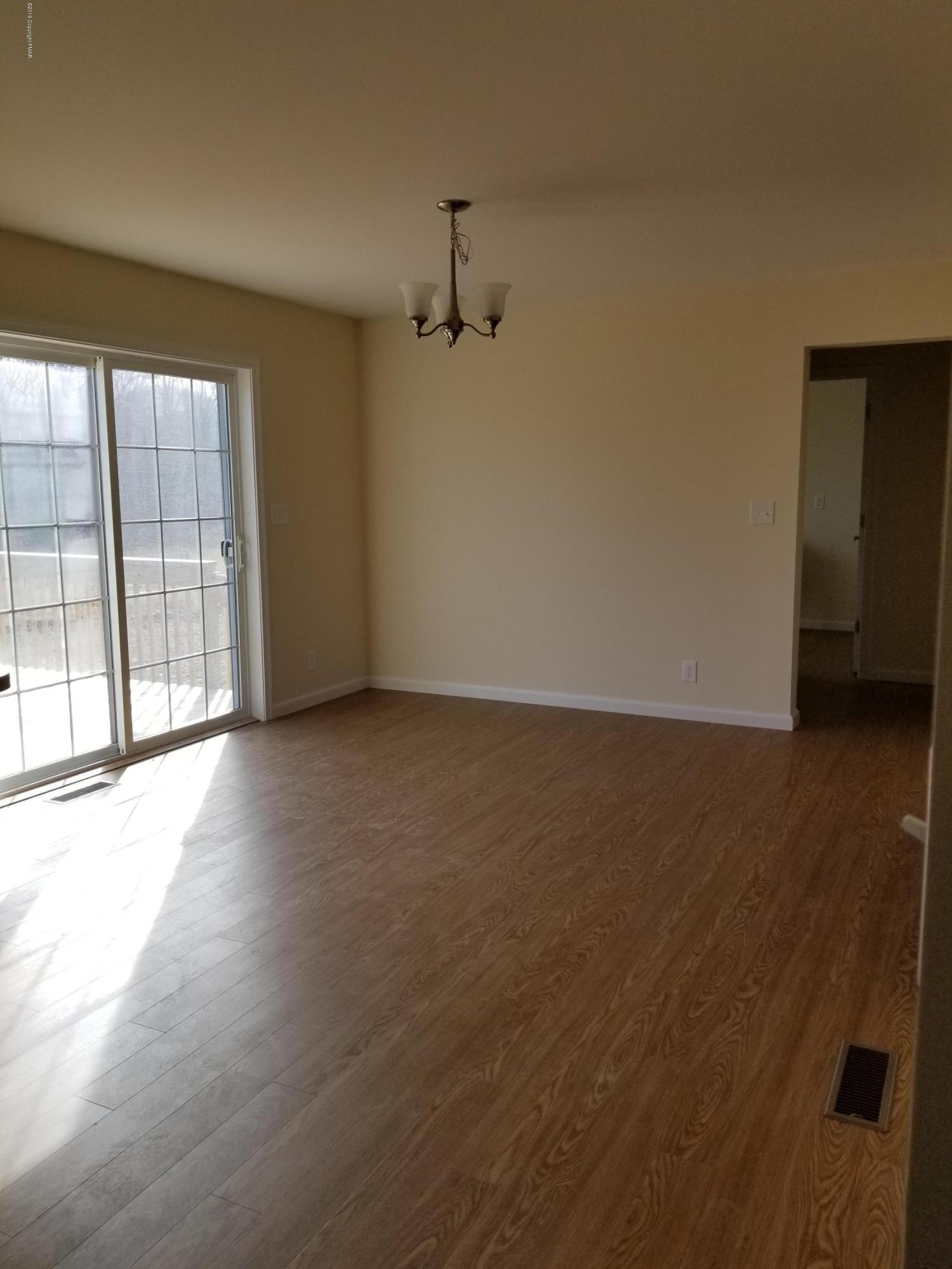 330 Chestnut Road Blakeslee, PA 18610 - Photo 14 of 29 an empty room with wooden floor and windows