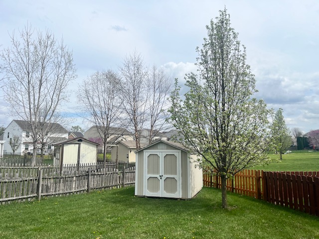 1978 Spring Ridge Drive Xenia, OH 45385 - Photo 42 of 44 This expansive yard features charming storage sheds and a blooming tree, perfect for outdoor enjoyment.
