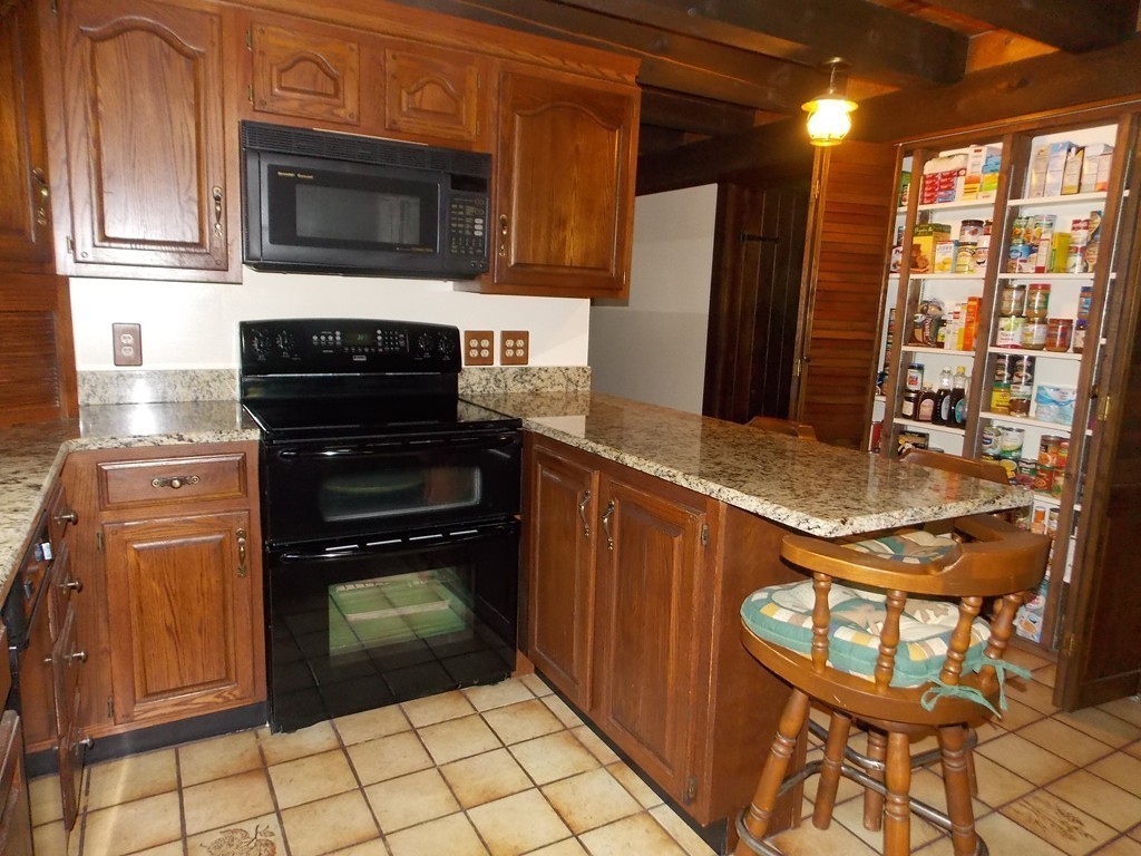 7 Betty Spring Road Freetown, MA 02717 - Photo 5 of 30 a kitchen with granite countertop a refrigerator and a stove top oven