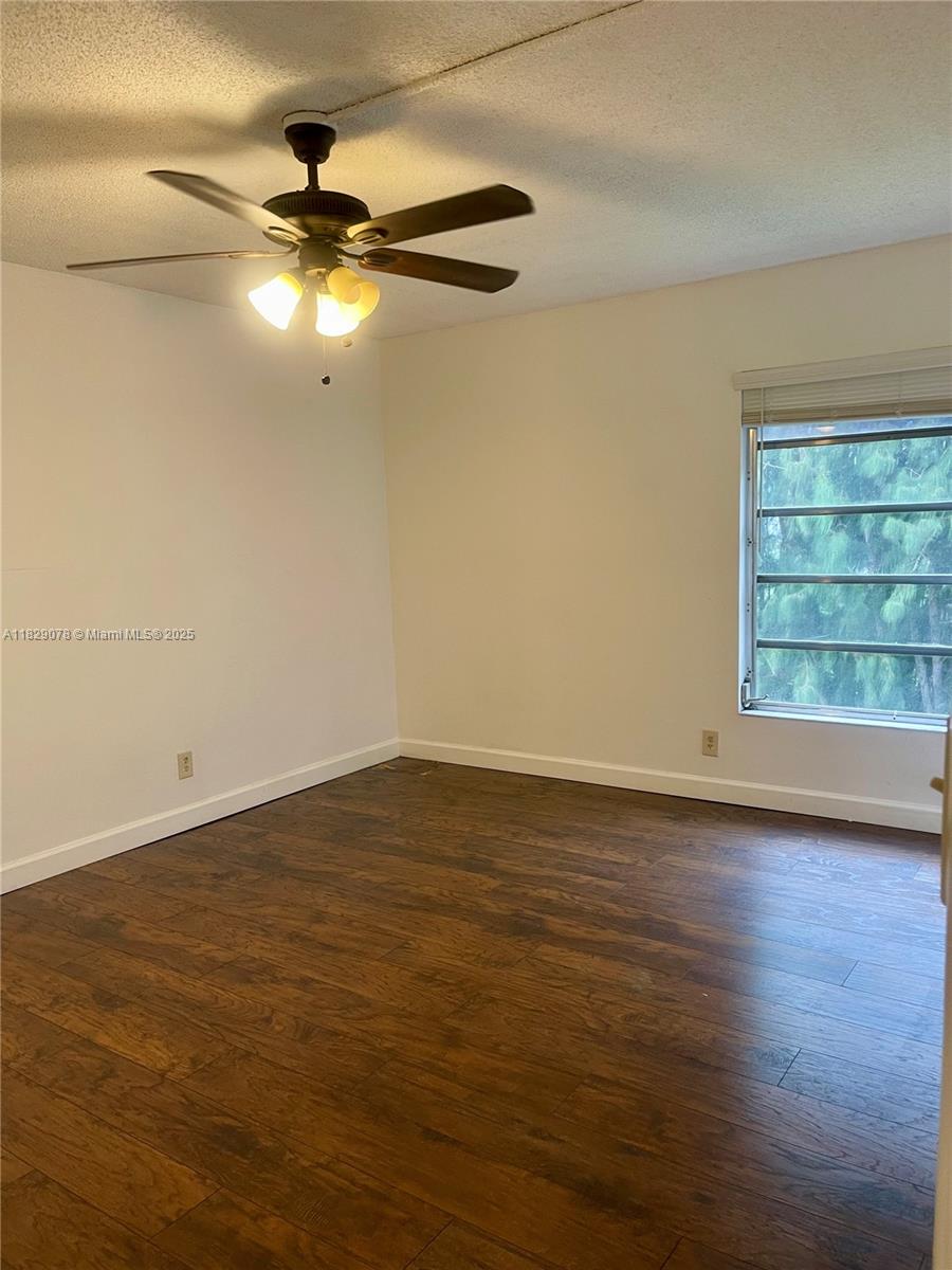 430 Commodore Drive, Unit 301 Plantation, FL 33325 - Photo 12 of 26 a view of an empty room with a window and wooden floor