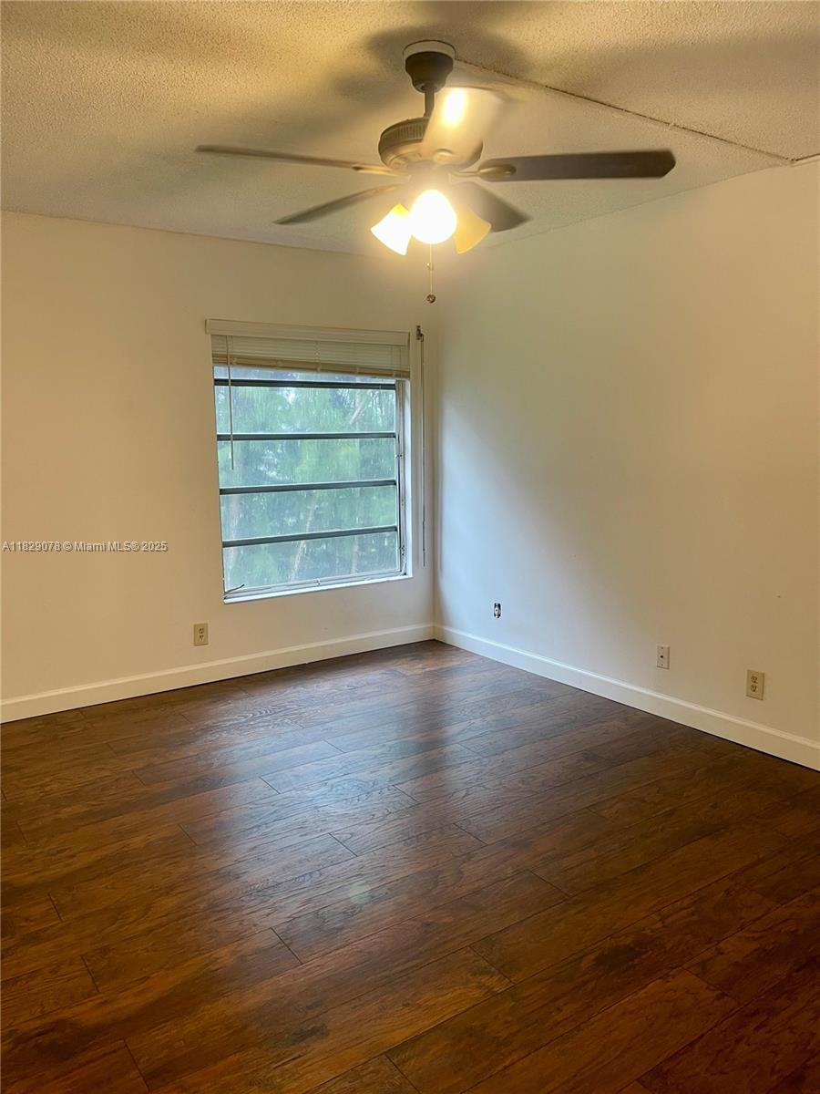 430 Commodore Drive, Unit 301 Plantation, FL 33325 - Photo 13 of 26 an empty room with wooden floor chandelier fan and windows