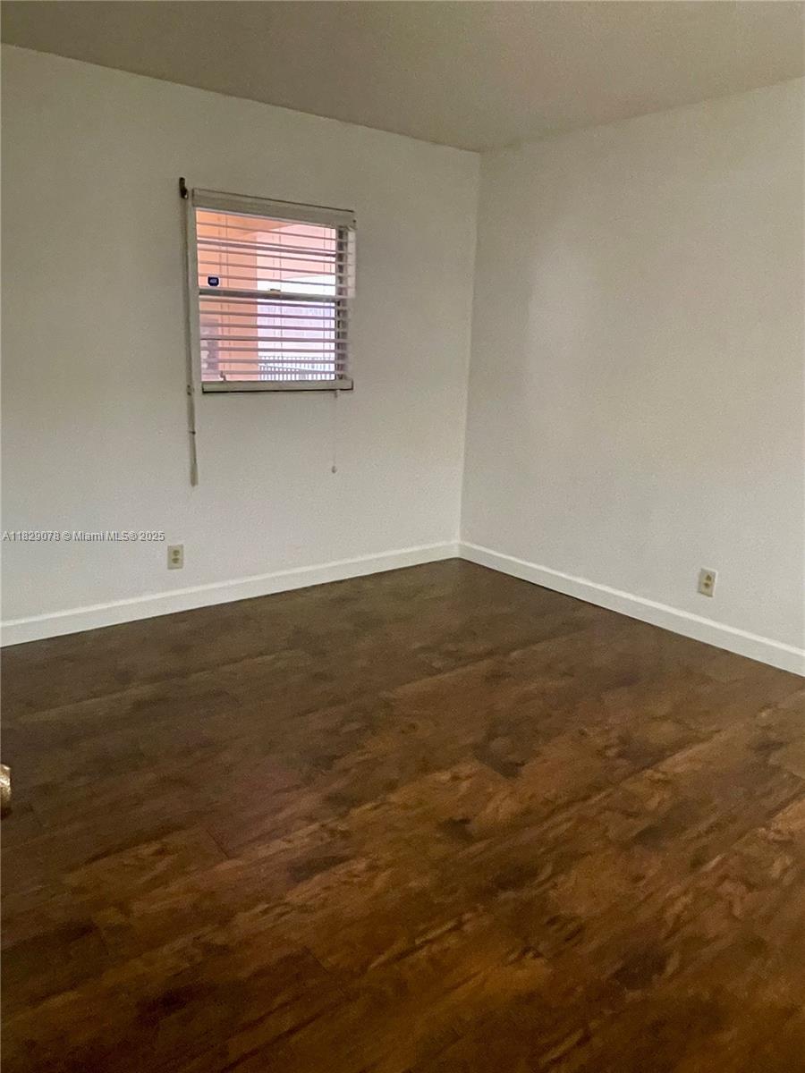 430 Commodore Drive, Unit 301 Plantation, FL 33325 - Photo 19 of 26 an empty room with wooden floor and windows