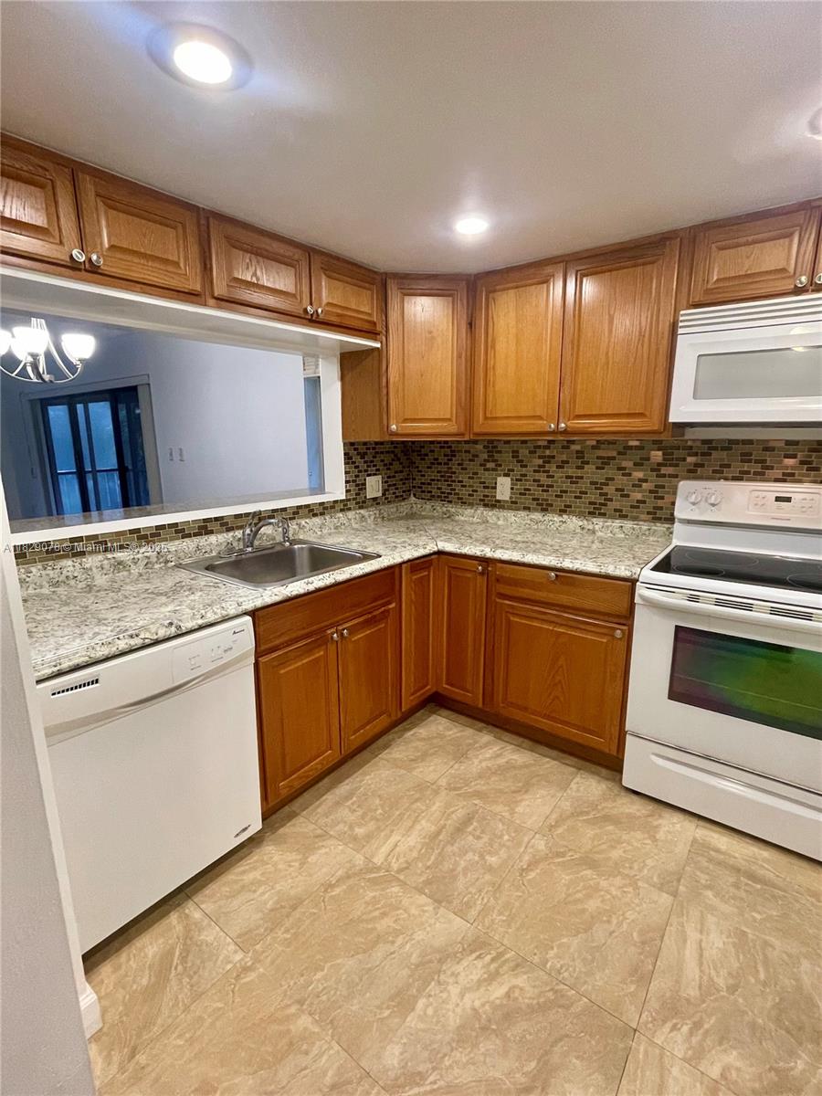 430 Commodore Drive, Unit 301 Plantation, FL 33325 - Photo 2 of 26 a kitchen with stainless steel appliances granite countertop a stove sink and cabinets