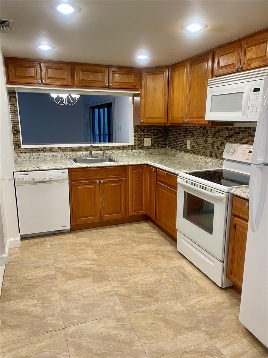 430 Commodore Drive, Unit 301 Plantation, FL 33325 - Photo 7 of 26 a kitchen with stainless steel appliances granite countertop a stove a sink and a microwave