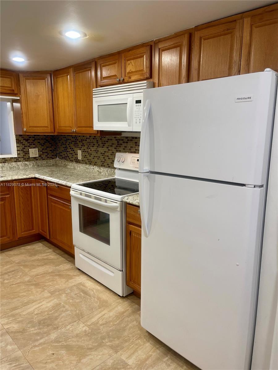 430 Commodore Drive, Unit 301 Plantation, FL 33325 - Photo 8 of 26 a white refrigerator freezer sitting in a kitchen