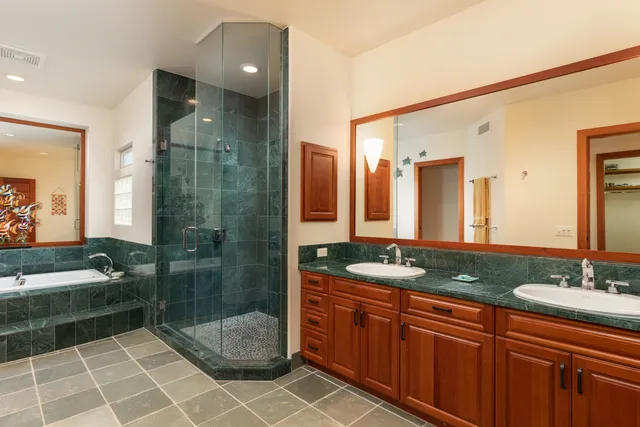 a bathroom with a granite countertop sink a toilet a mirror and shower