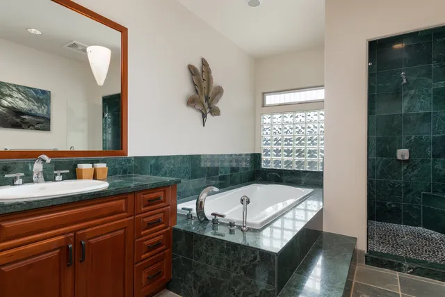 a bathroom with a tub a sink and a mirror