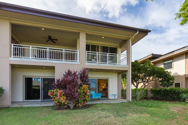 a view of a house with brick walls and a yard with potted plants