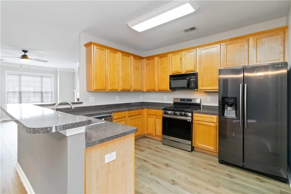 3864 Guilderoy Lane, Unit 3 Austell, GA 30106 - Photo 8 of 27 a kitchen with stainless steel appliances granite countertop a stove a sink and a refrigerator