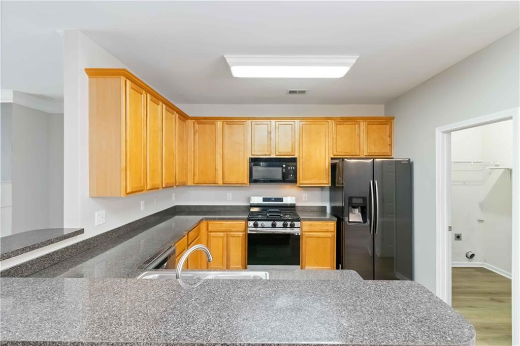 3864 Guilderoy Lane, Unit 3 Austell, GA 30106 - Photo 10 of 27 a kitchen with a refrigerator a stove top oven a sink and cabinets