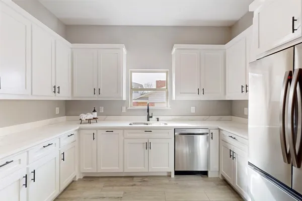 a kitchen with white cabinets stainless steel appliances and sink