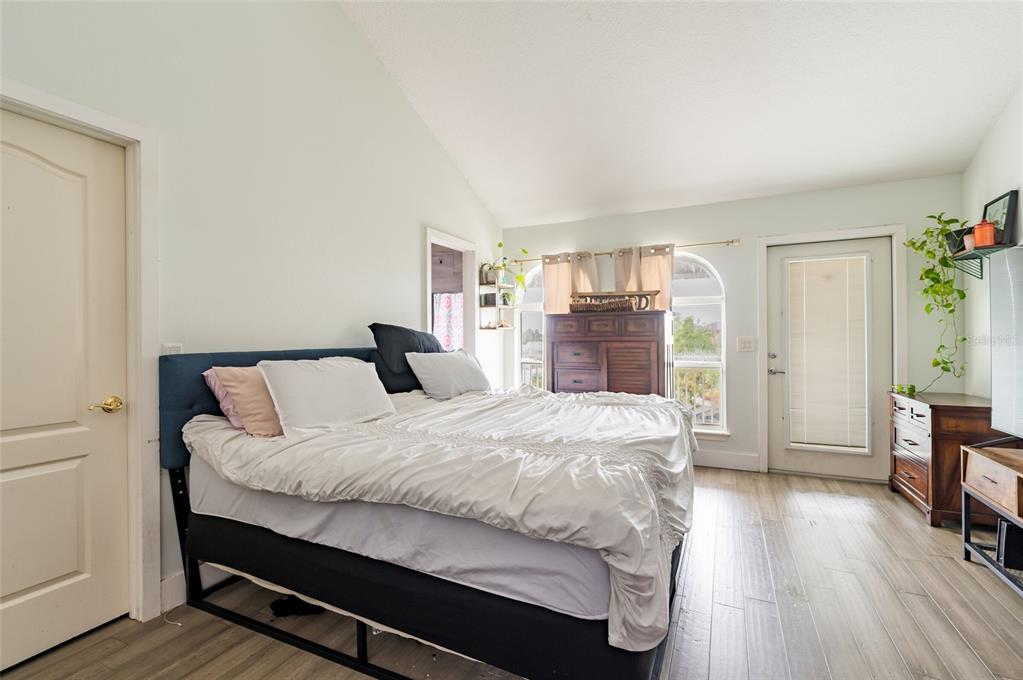 2204 1st Street, Unit F Indian Rocks Beach, FL 33785 - Photo 11 of 37 a bedroom with a bed and wooden floor