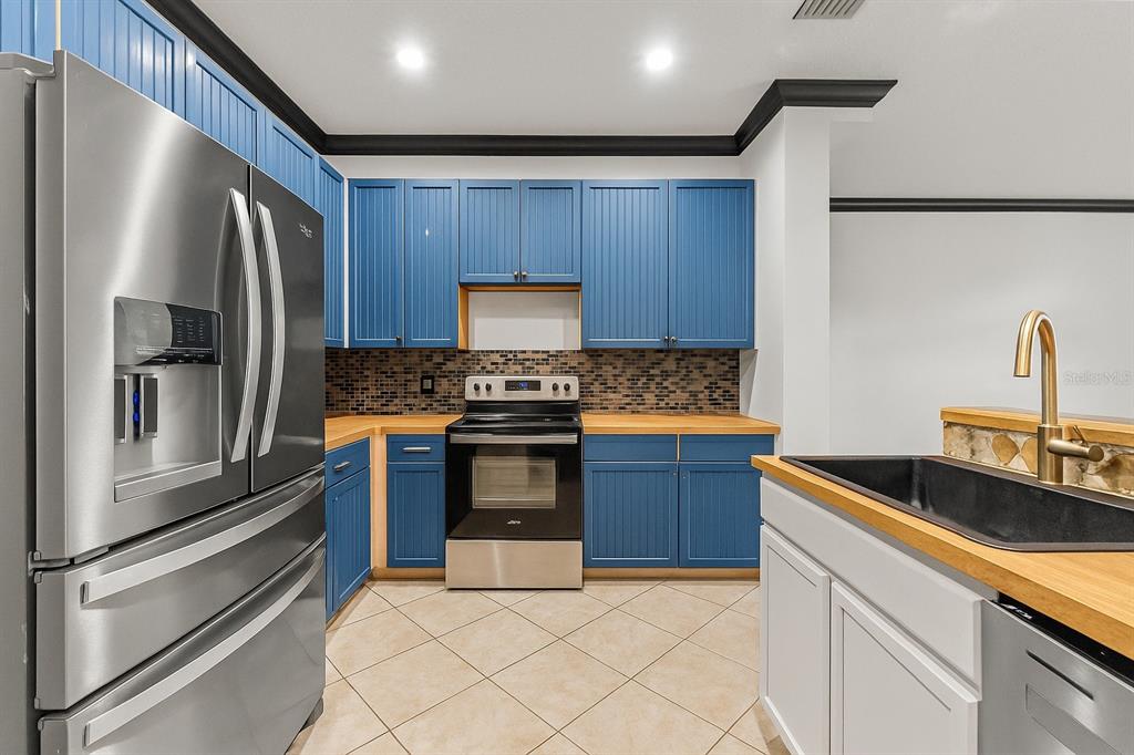 2204 1st Street, Unit F Indian Rocks Beach, FL 33785 - Photo 22 of 37 a kitchen with granite countertop a refrigerator stove and sink