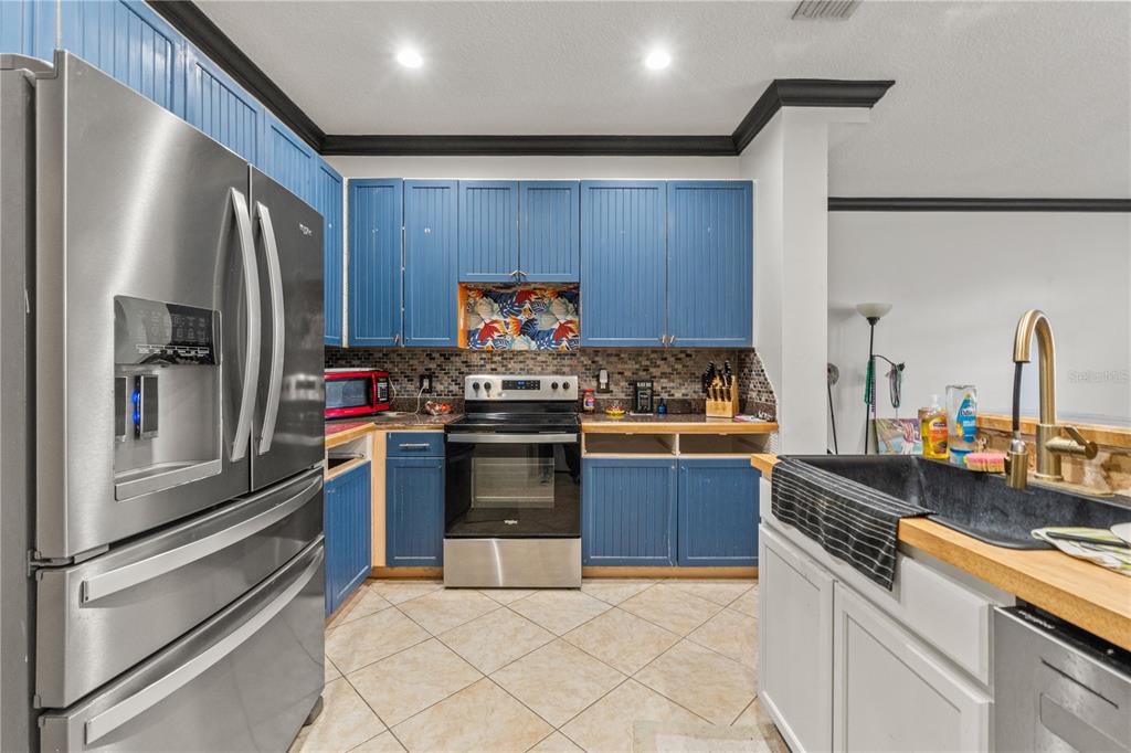 2204 1st Street, Unit F Indian Rocks Beach, FL 33785 - Photo 23 of 37 a kitchen with stainless steel appliances granite countertop a refrigerator and a stove