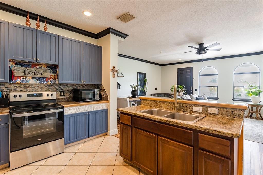 2204 1st Street, Unit F Indian Rocks Beach, FL 33785 - Photo 8 of 37 a kitchen with stainless steel appliances granite countertop a sink and cabinets