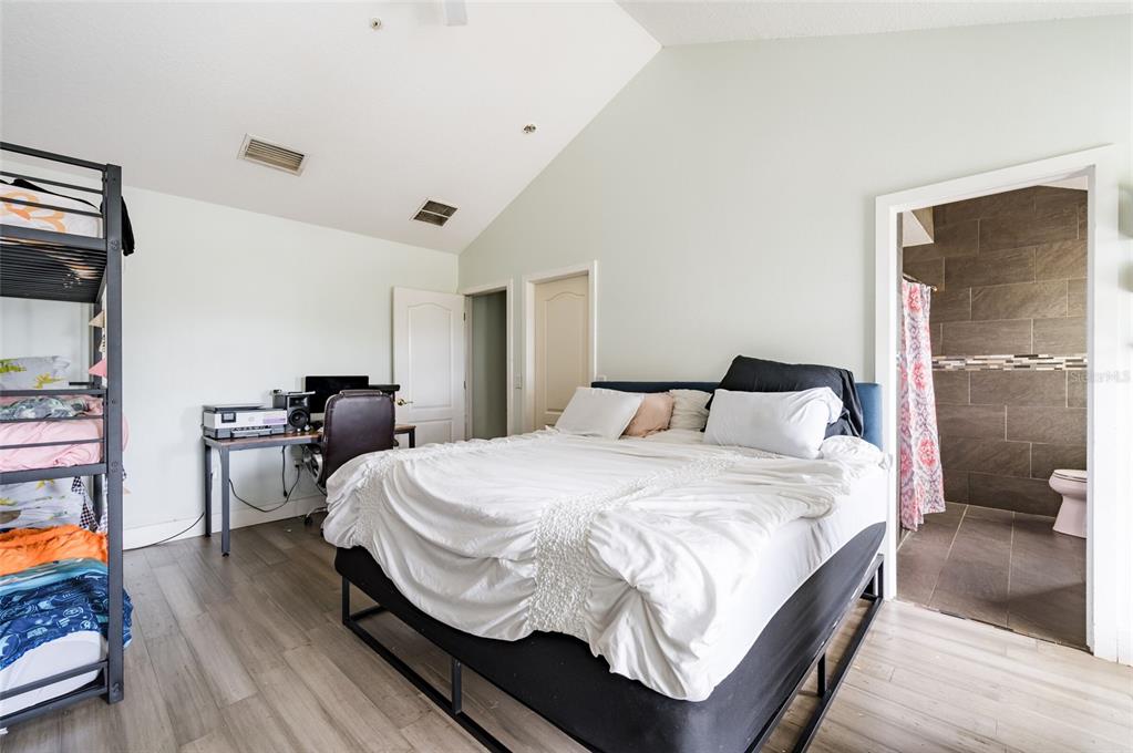 2204 1st Street, Unit F Indian Rocks Beach, FL 33785 - Photo 10 of 37 a bedroom with a bed and wooden floor