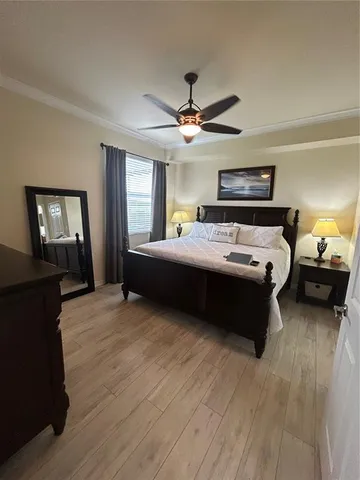 a bedroom with a bed ceiling fan and a window