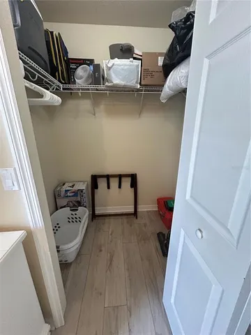 a view of walk in closet with clothes and shoes