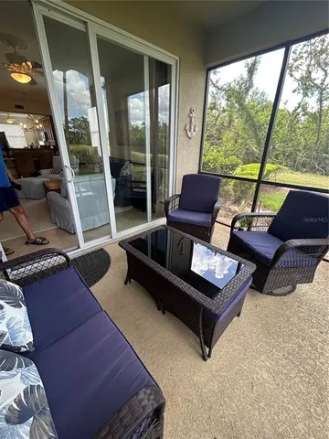 a living room with furniture and a floor to ceiling window