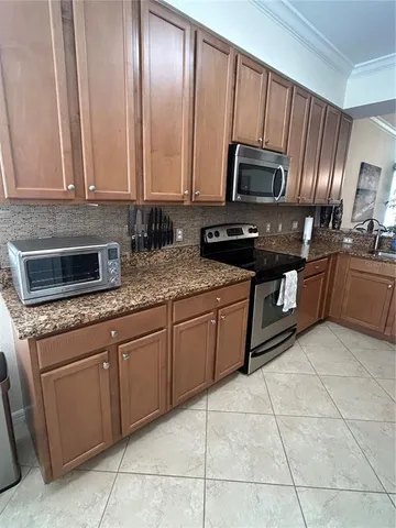 a kitchen with stainless steel appliances granite countertop a stove a sink and a microwave