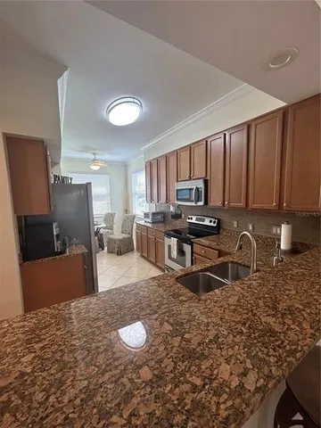 a kitchen with granite countertop a refrigerator stove top oven a sink and dishwasher