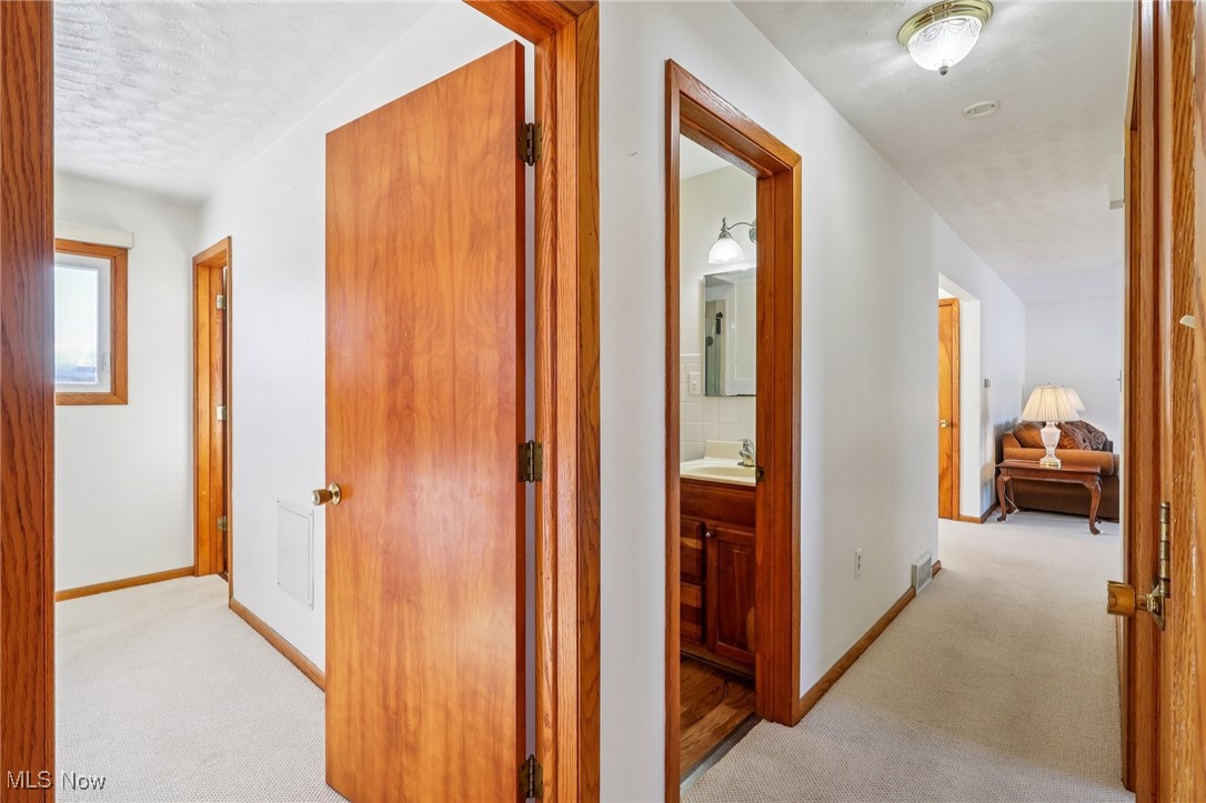 970 Eastern Road Doylestown, OH 44230 - Photo 16 of 49 Hallway featuring light carpet and baseboards