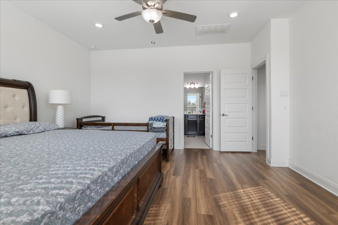 240 Inlet Lane Leander, TX 78641 - Photo 17 of 33 a spacious bedroom with a bed and a chandelier