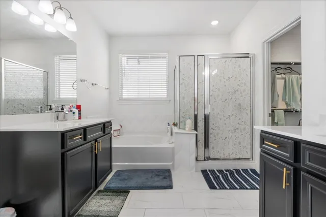 a bathroom with a tub a sink and a mirror