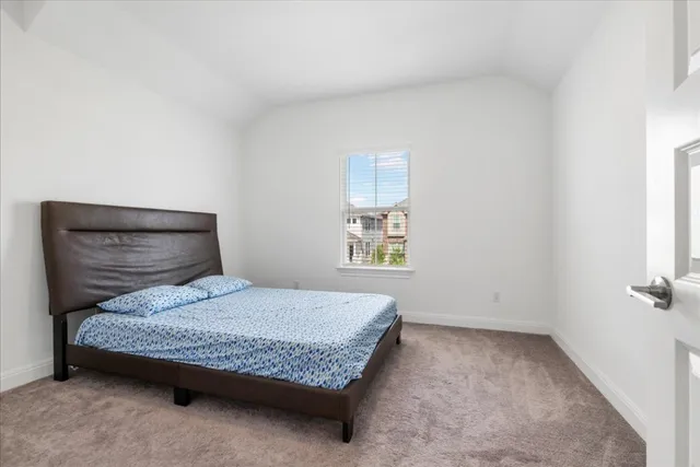 a bedroom with a bed and painting on the wall