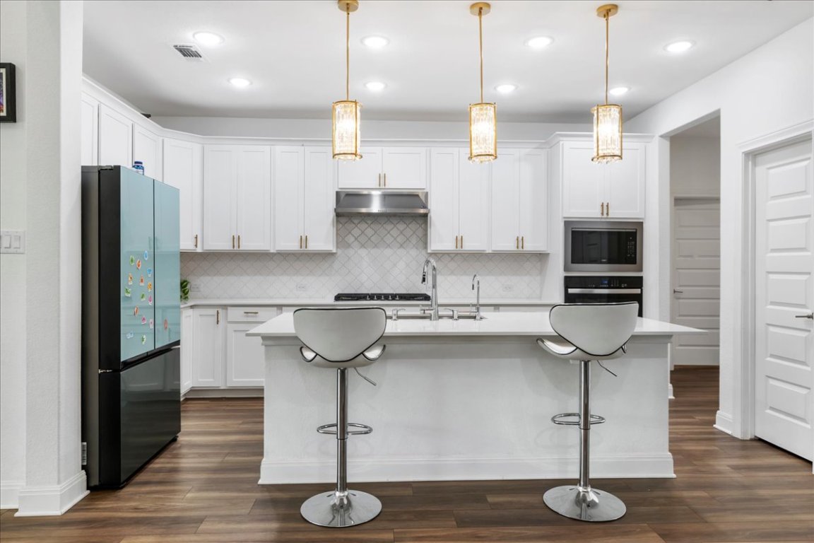 240 Inlet Lane Leander, TX 78641 - Photo 5 of 33 a kitchen with stainless steel appliances granite countertop a sink a refrigerator and a stove