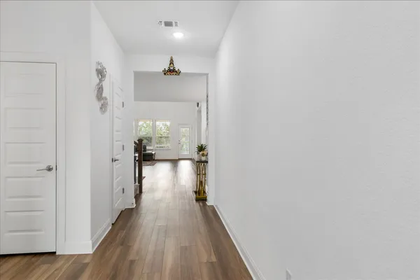 a view of a hallway with wooden floor and staircase