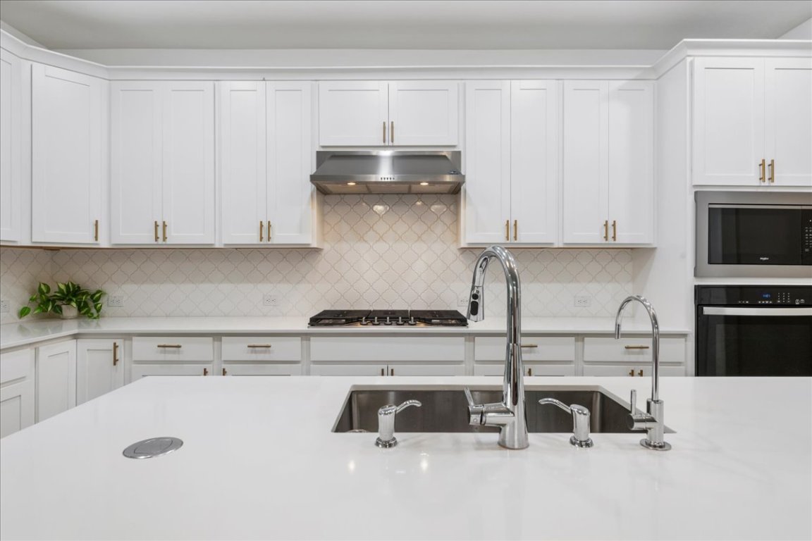 240 Inlet Lane Leander, TX 78641 - Photo 8 of 33 a kitchen with kitchen island a sink a stove and cabinets