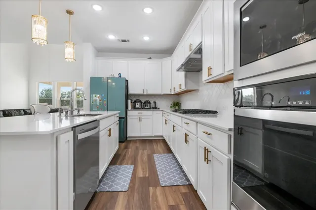 a large kitchen with stainless steel appliances kitchen island granite countertop a sink and cabinets