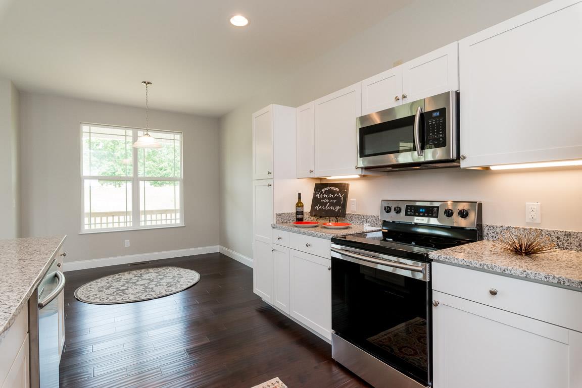 708 Ruby Way White Bluff, TN 37187 - Photo 7 of 30 a kitchen with stainless steel appliances granite countertop a stove a microwave a sink and white cabinets