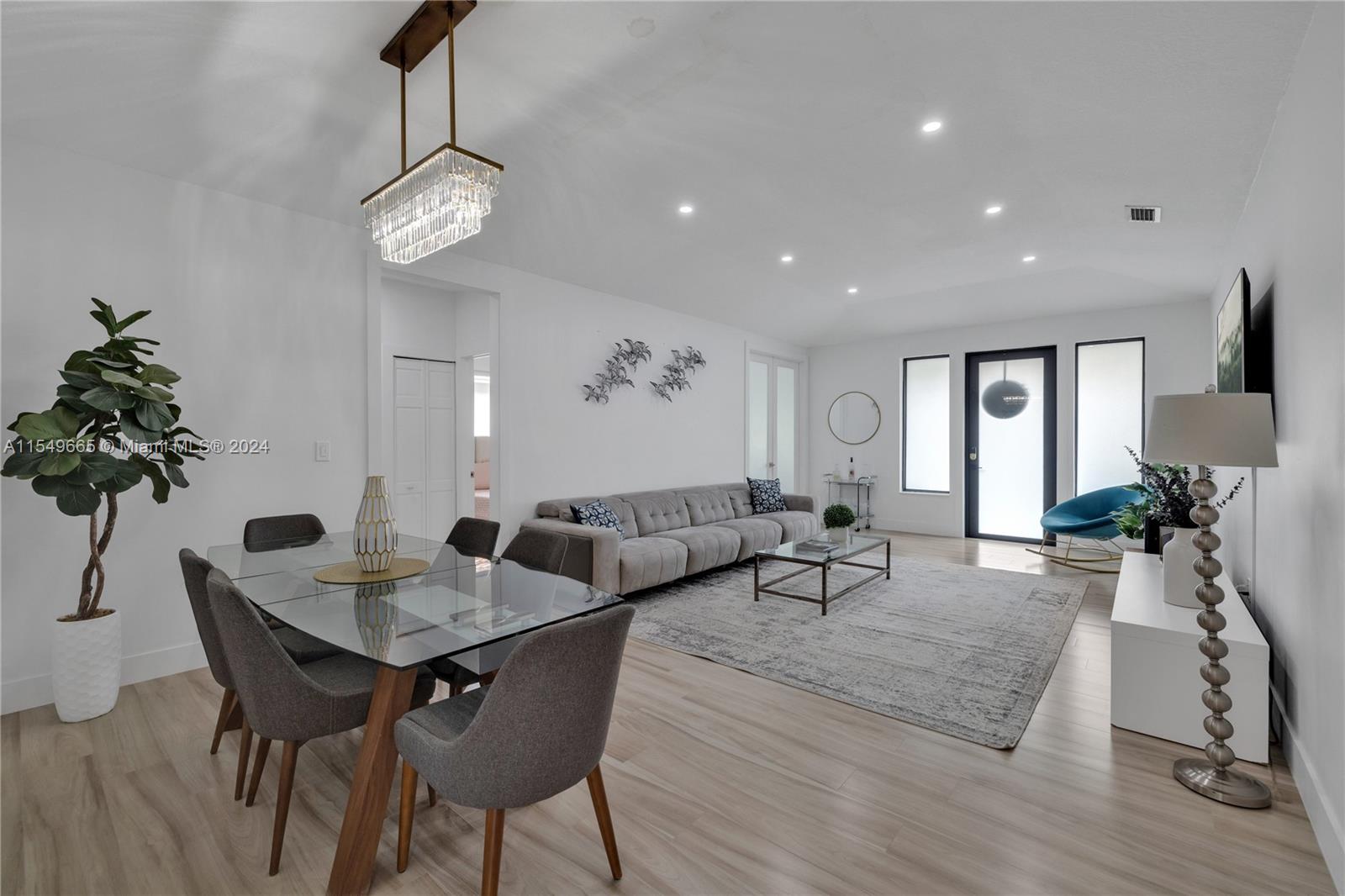 1543 Bird Road Coral Gables, FL 33146 - Photo 15 of 65 a living room with furniture a chandelier and a wooden floor