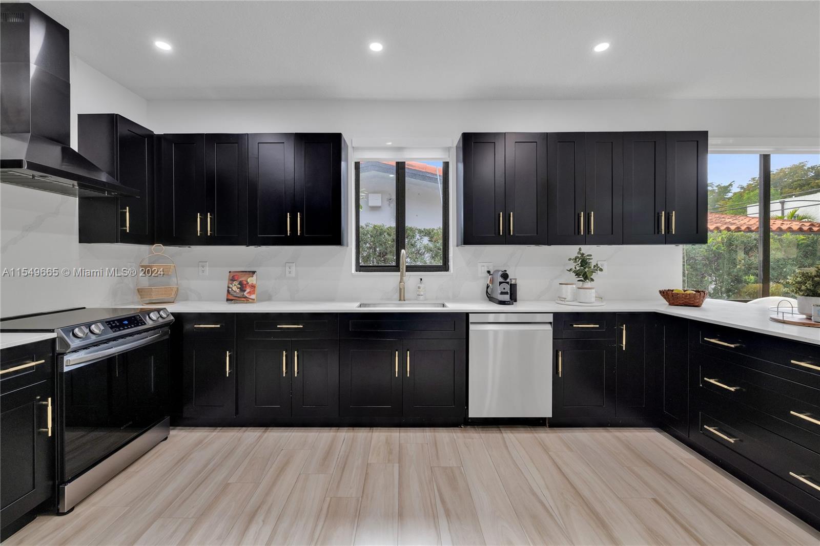 1543 Bird Road Coral Gables, FL 33146 - Photo 19 of 65 a kitchen with stainless steel appliances kitchen island granite countertop a sink and cabinets