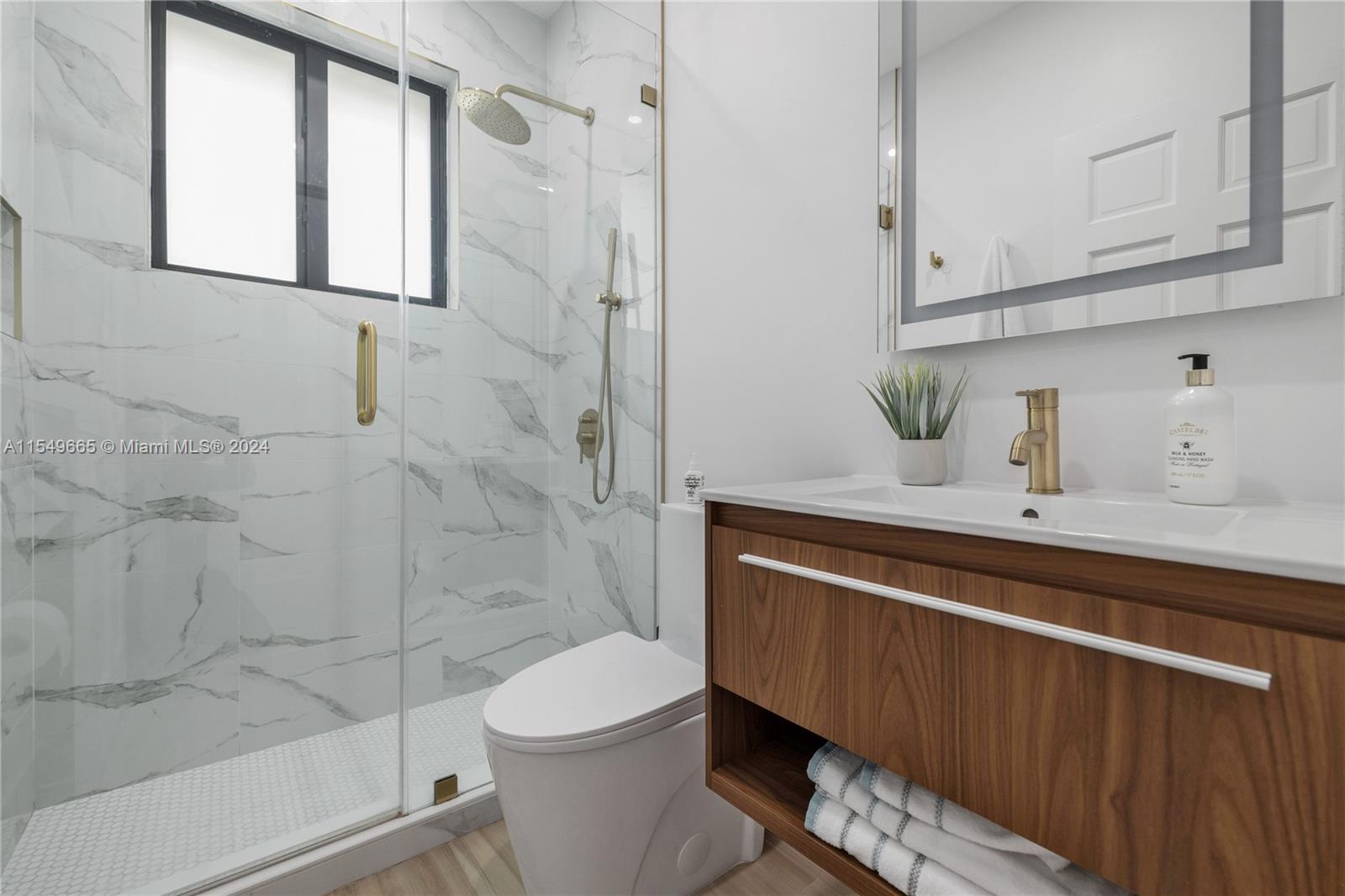 1543 Bird Road Coral Gables, FL 33146 - Photo 38 of 65 a bathroom with a sink a toilet and shower