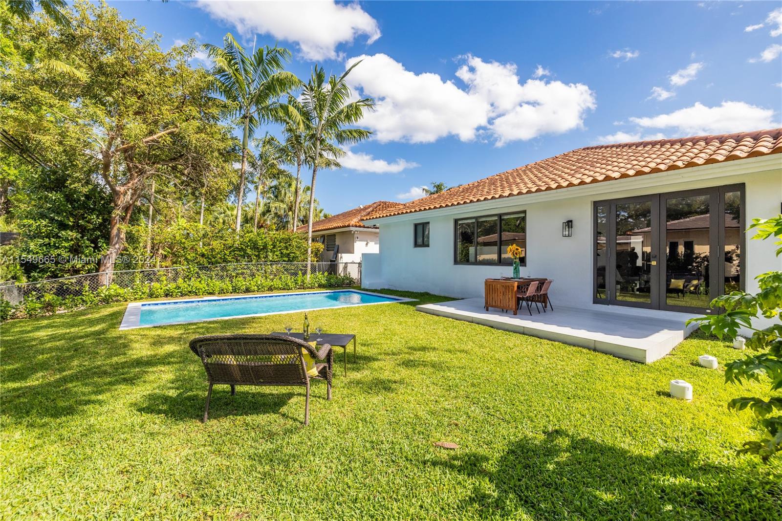 1543 Bird Road Coral Gables, FL 33146 - Photo 41 of 65 a swimming pool with outdoor seating and yard