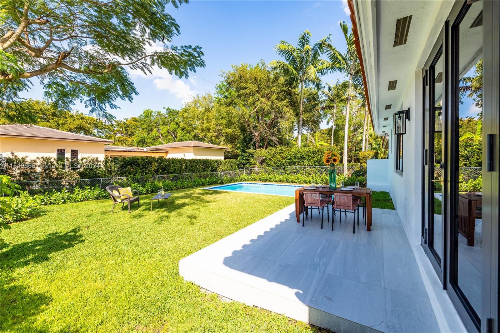 1543 Bird Road Coral Gables, FL 33146 - Photo 42 of 65 a view of a swimming pool with an outdoor seating and a yard