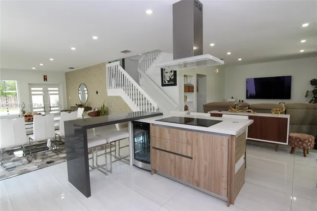 a kitchen with stainless steel appliances kitchen island hardwood floor and a sink