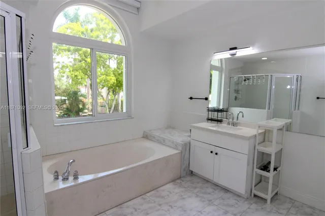 a bathroom with a tub sink and mirror