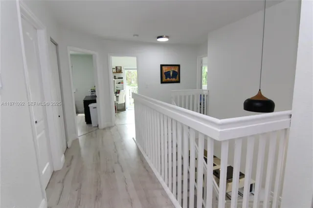 a view of a hallway with wooden floor and stairs